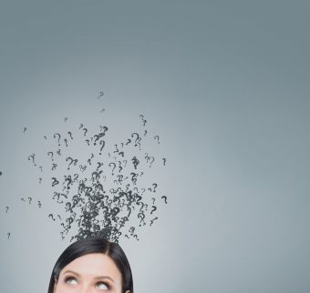 Top of a woman's head with question marks floating above it