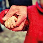 Adult and child holding hands