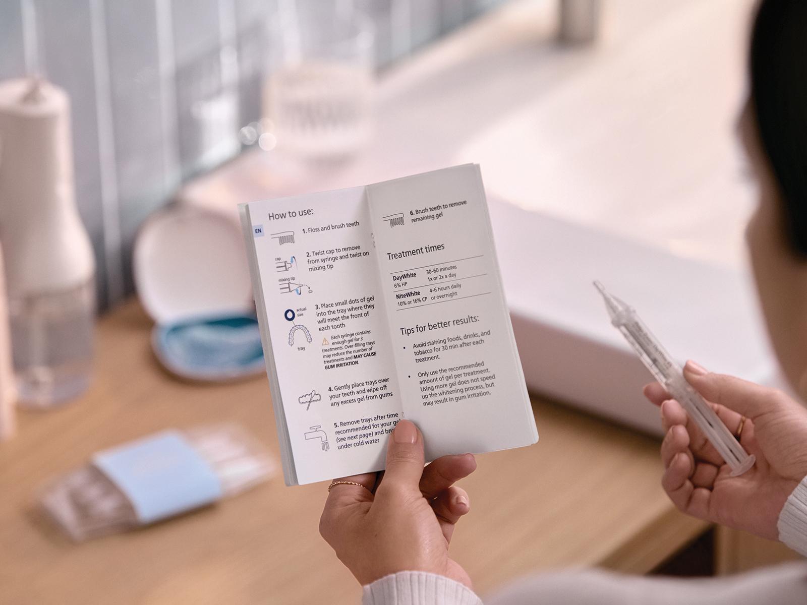 A patient reads the instruction leaflet for the first time, while holding one of the whitening solution syringes.