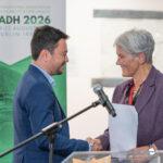 Dr Kamenov and Prof Dougall shake hands on stage.